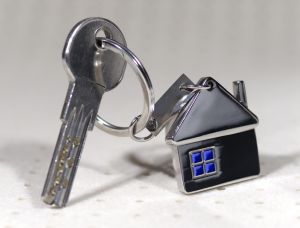 House symbol with silver keys on abstract background. Real estate concept
