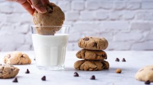 Chocolate chip cookies with a glass of milk on a marble background