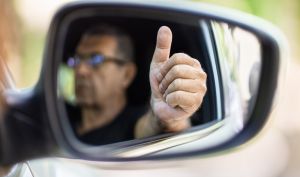 Senior in his 70s driving a car