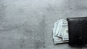 us dollars money in male black wallet on gray background
