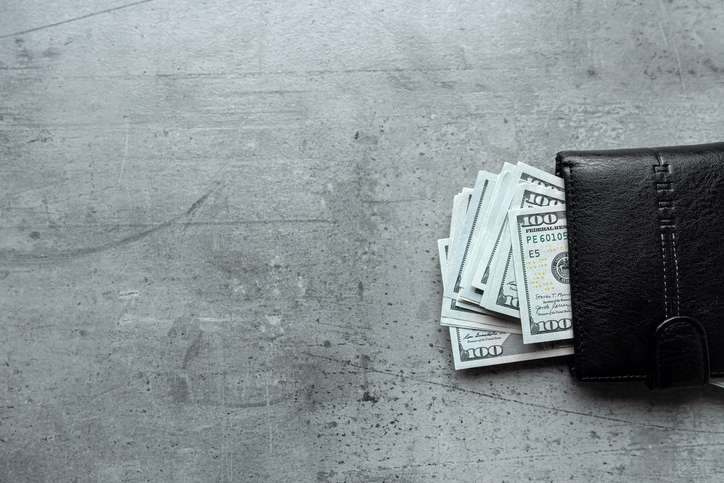 us dollars money in male black wallet on gray background