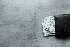 us dollars money in male black wallet on gray background