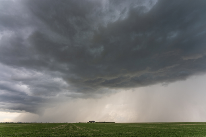 Dark storm clouds gathering over farmland