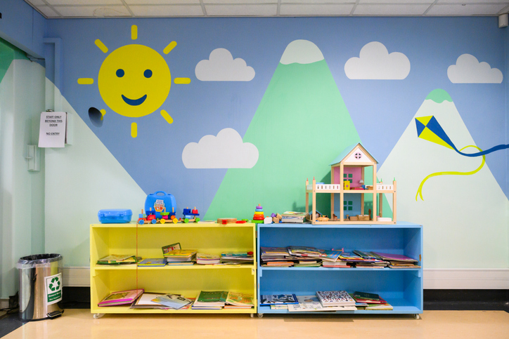 Colorful children's reading and play area with books and toys on shelves