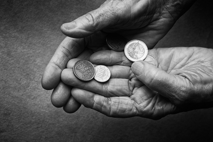 Close-up of seniors hands holding coins.