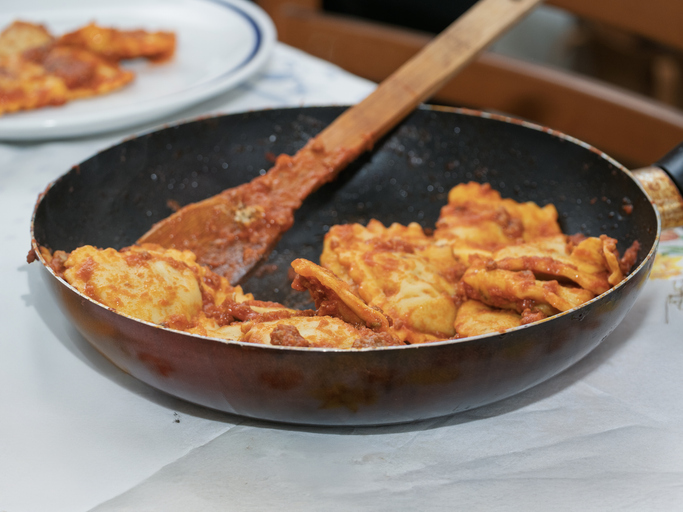 Italian pasta: ravioli and parmesan on a table. outdoor lunch in italy. iconic italian food at a restaurant. eating out concept