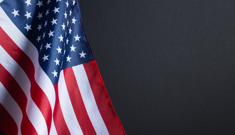 Background for Memorial Day posters, Veterans Day banners, and patriotic holiday designs. American flag on black background with copy space honoring soldiers and veterans.