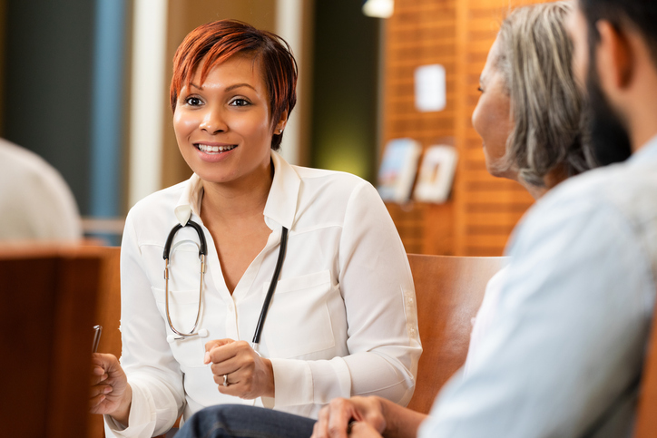 Doctor consults with patients in a healthcare setting, discussing medical matters.