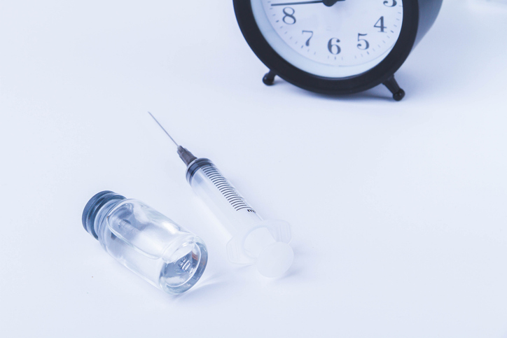 Time for vaccination. Watch and syringe with vaccine. Date and time of preventive vaccinations to population.