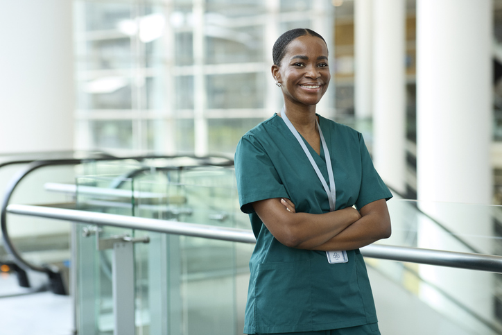 Smiling nurse standing with arms crossed