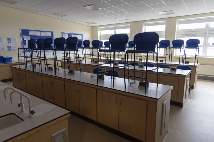 An empty high school classroom with chairs arranged on desks