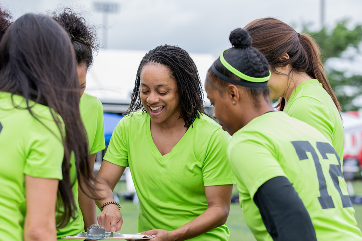 Women’s flag football team huddled together