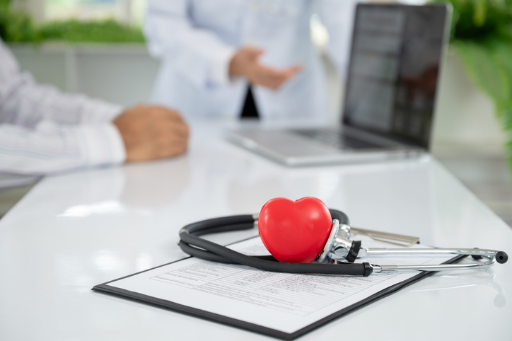 healthcare and medical concept. stethoscope and heart on research report with cardiologist team at cardiology center.