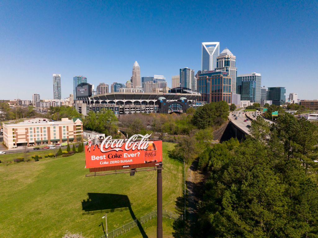 Aerial View of Charlotte, North Carolina on clear day showing highways and skyline shows classic Coca Cola red billboard