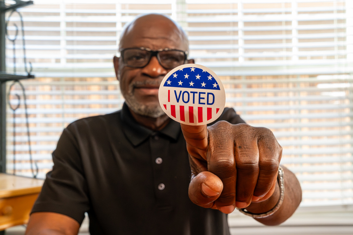 Civic participation. Senior citizen displays voting badge.
