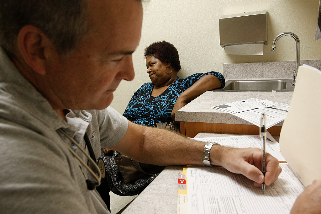 Regina Tate speaks to James Gocke, a family nurse practitioner, during an examination at the Antelo