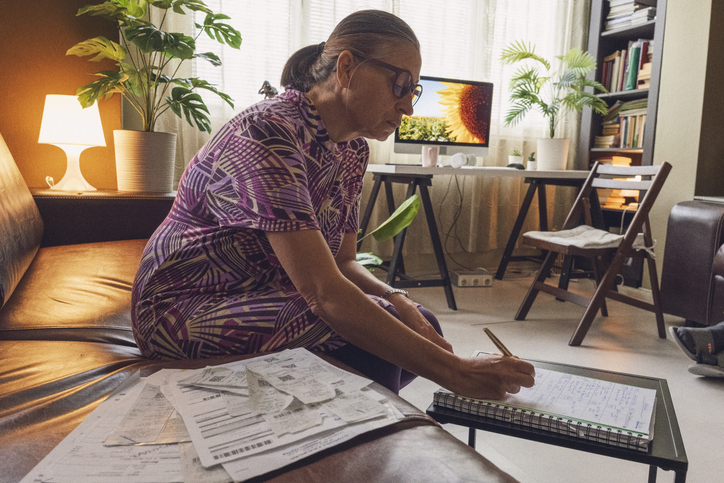 Mature Woman Budgeting Expenses Checking Receipts.Tax Preparation