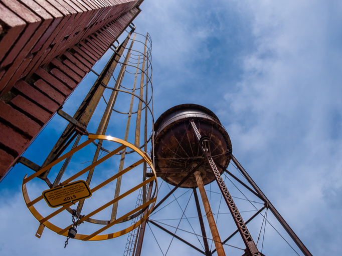 Old water tower and safety ladder at Camp North End in Charlotte, North America, USA with blue sky and clouds
