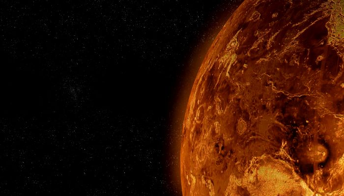 A fiery, orange-red planet against a dark, starry background.
