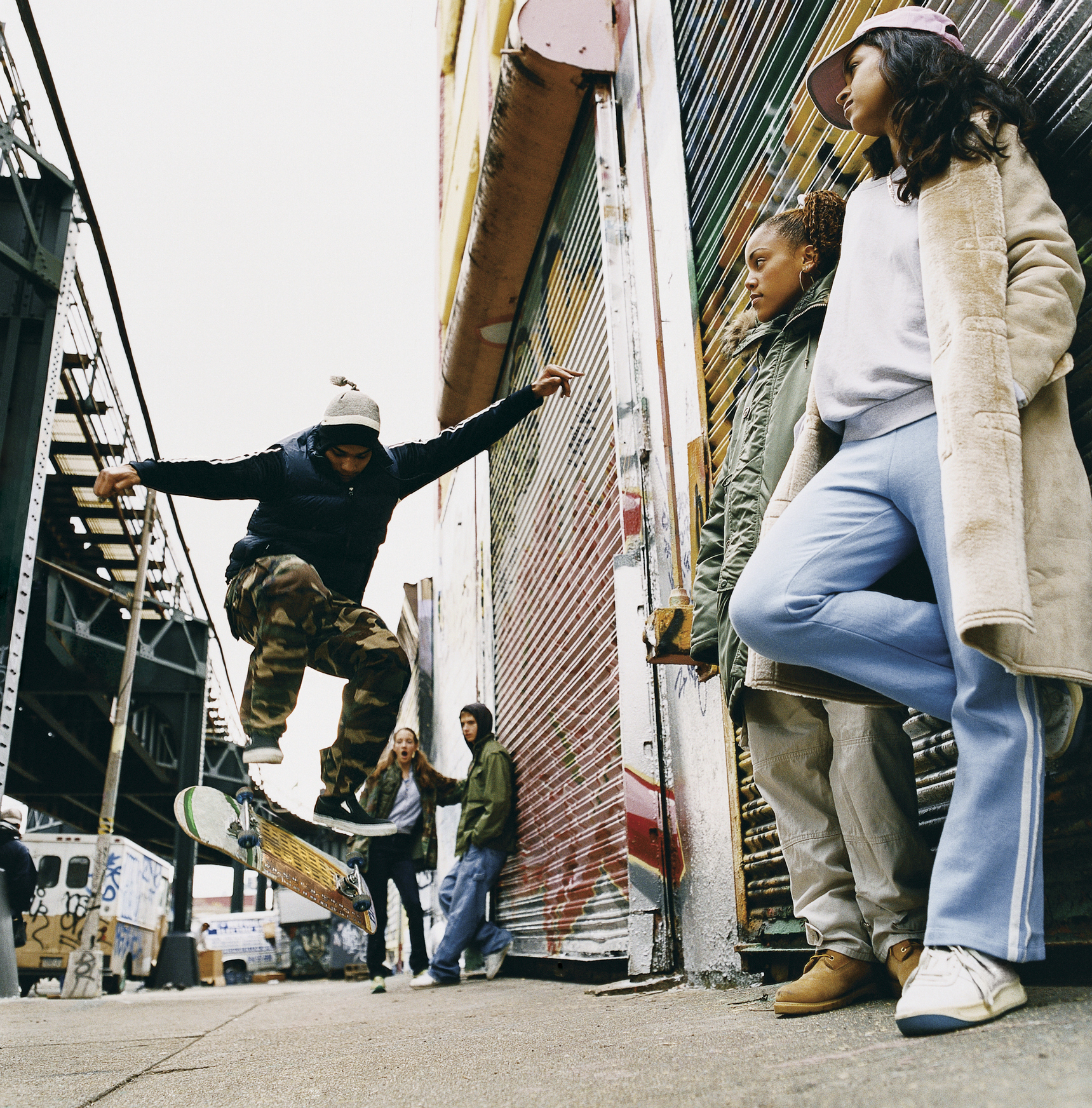 Medium Group of Teenagers in a Back Alley Watching Stunts on a Skateboard