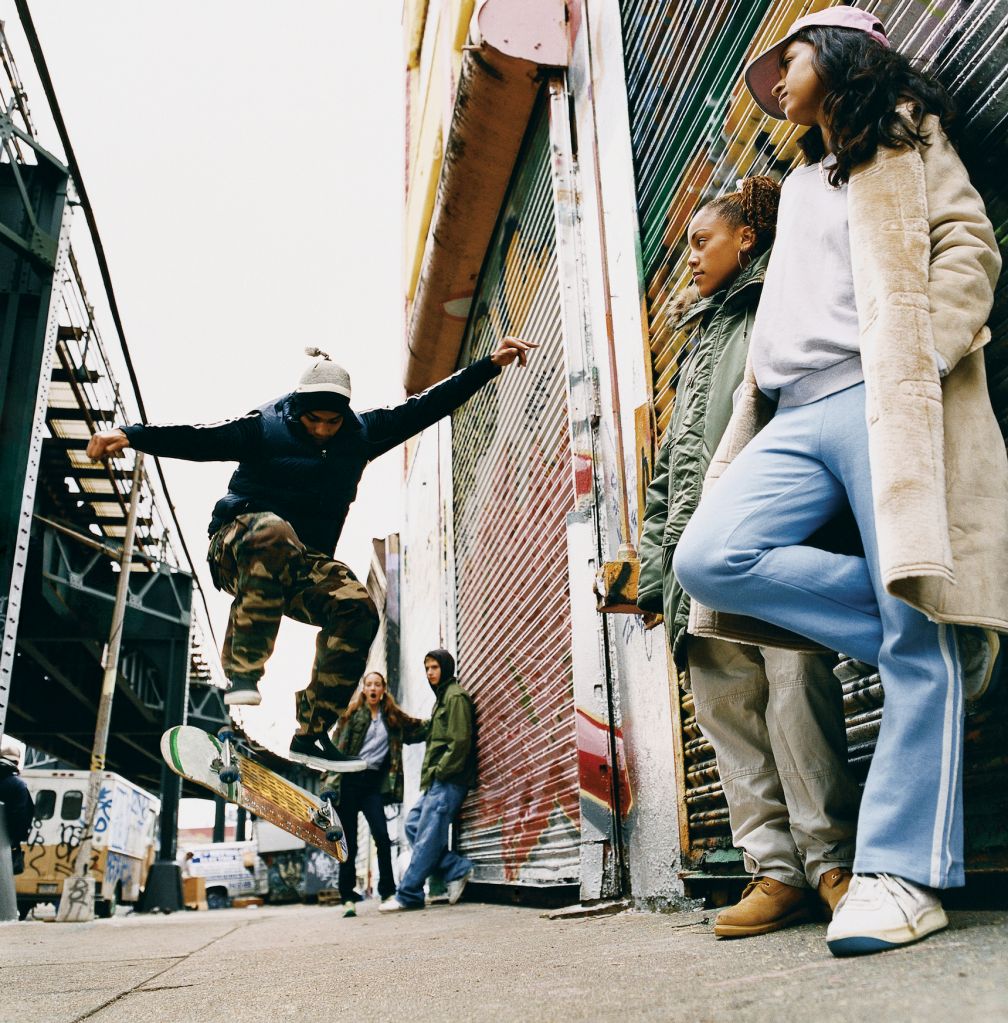 Medium Group of Teenagers in a Back Alley Watching Stunts on a Skateboard