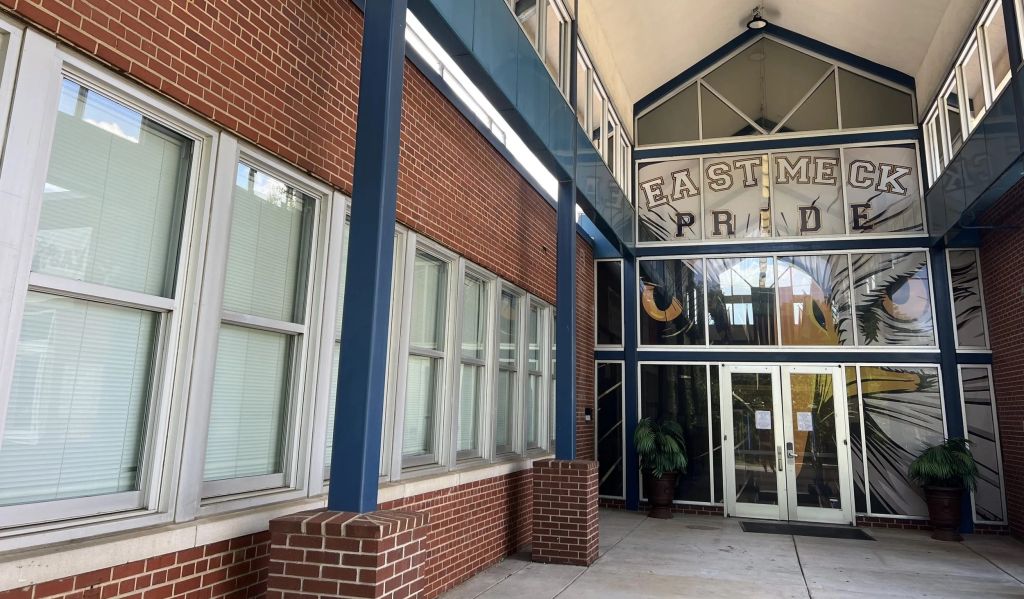 Exterior of a brick building with large windows and a sign that reads "EAST MECK PRIDE".